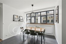 Vue de la pièce à vivre dans un appartement en location meublée à Paris.