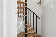 Escalier menant à la suite parentale dans une location meublée à Paris.