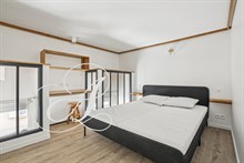 Lit double de la chambre principale dans une location meublée à Paris proche de Montparnasse.